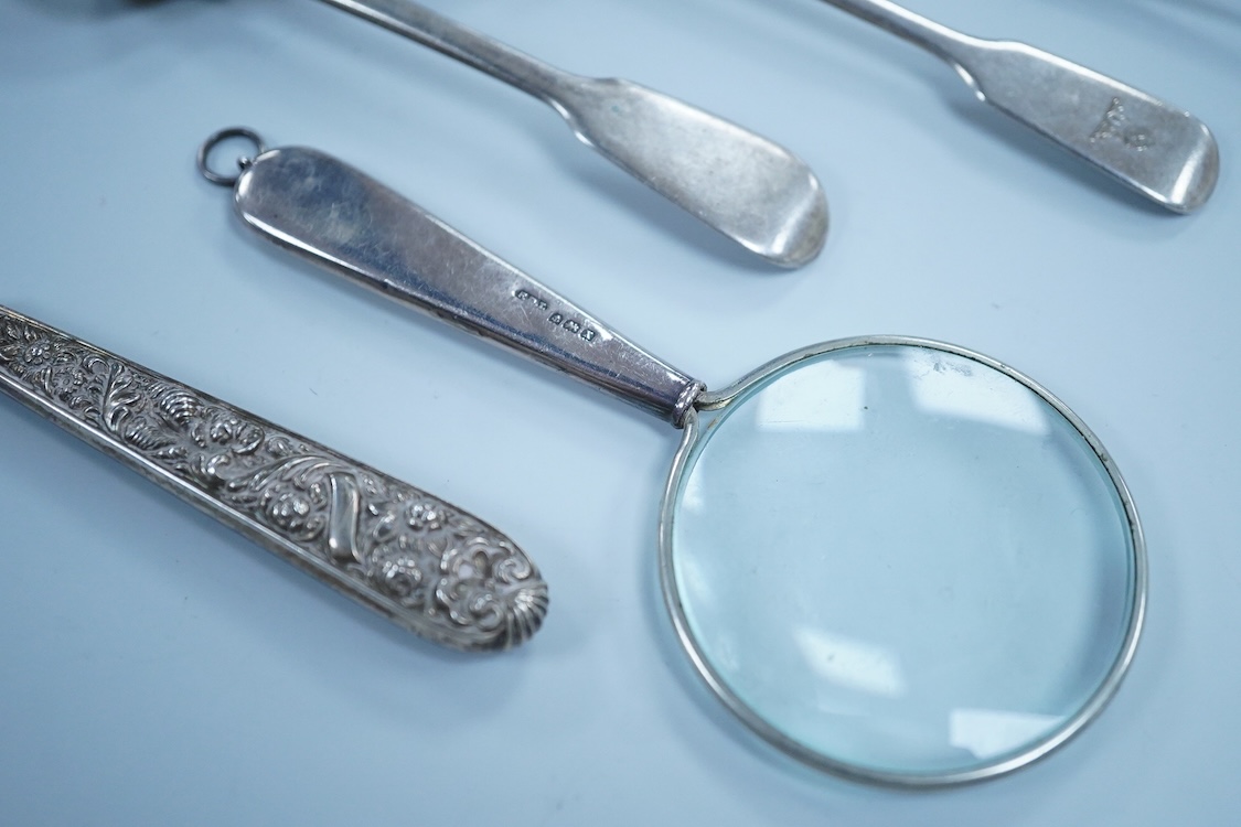 Two William IV silver fiddle pattern condiment spoons, both London 1831, a Victorian silver gilt ear wax spoon(lacking handle), two other silver spoons, a small white metal fork and a silver handled magnifying glass.